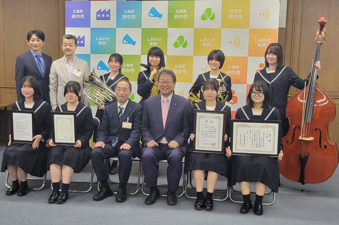 賞状と楽器を持って市長・教育長と記念撮影をした写真